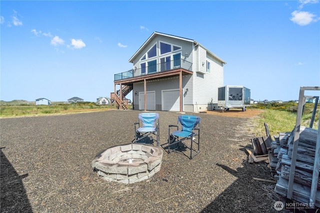 1438 Ocean Crest Ave SW, Ocean Shores, WA 98569 - back of house with a fire pit, stairway, an attached garage, driveway, and a wooden deck
