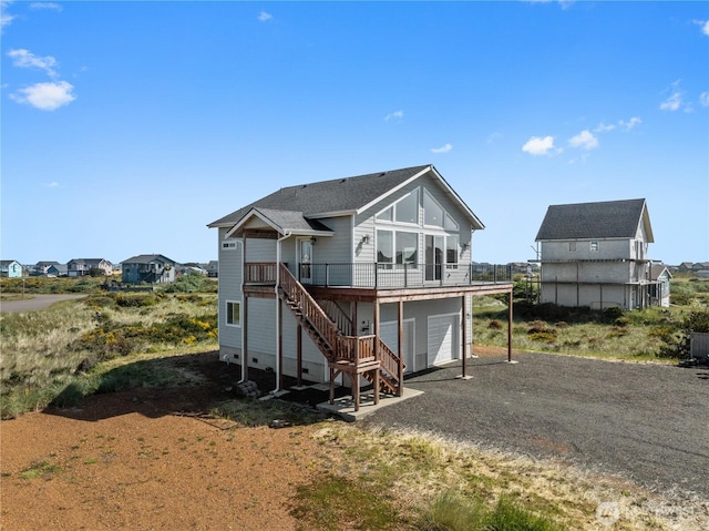 1438 Ocean Crest Ave SW, Ocean Shores, WA 98569 - back of house featuring driveway, a wooden deck, stairs, a garage, and roof with shingles