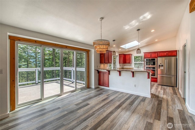 16 Village View Rd, Orcas Island, WA 98245 - kitchen with appliances with stainless steel finishes, reddish brown cabinets, a chandelier, a peninsula, and plenty of natural light
