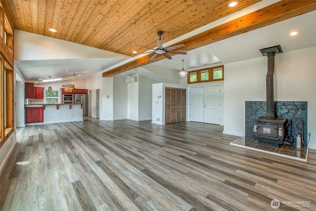 16 Village View Rd, Orcas Island, WA 98245 - unfurnished living room with a wood stove, ceiling fan, dark wood-style flooring, a wall mounted air conditioner, and recessed lighting