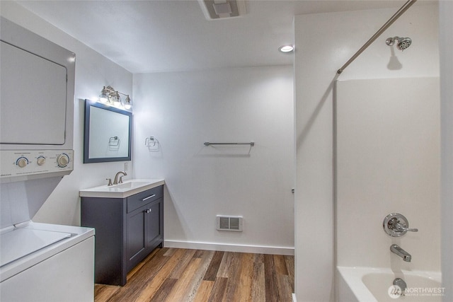 16 Village View Rd, Orcas Island, WA 98245 - full bathroom with estacked washer and dryer, vanity, shower / washtub combination, wood finished floors, and baseboards