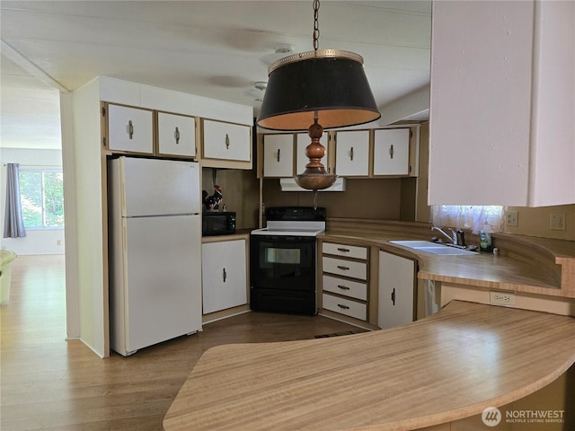 14721 Morris Rd Unit 21, Randle, WA 98377 - kitchen with freestanding refrigerator, electric range oven, black microwave, a sink, and white cabinetry