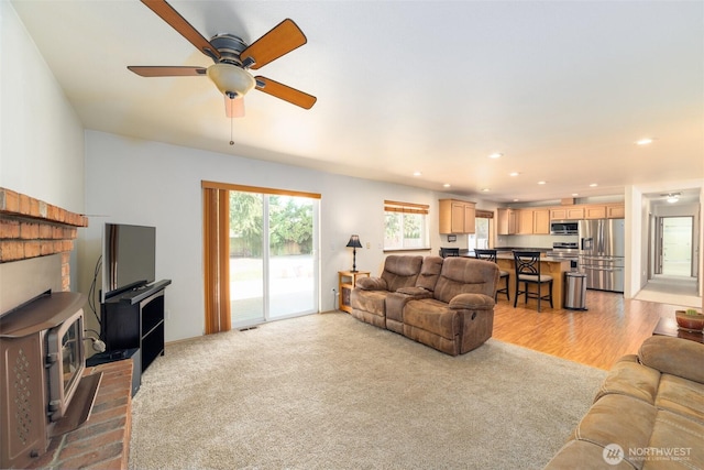 14415 144th St E, Orting, WA 98360 - living room with a wood stove, ceiling fan, light carpet, and recessed lighting