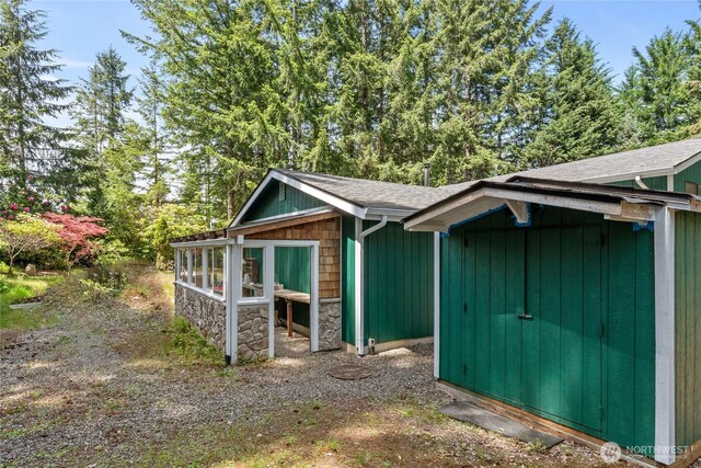 60 E Christmas Tree Pl, Belfair, WA 98528 - view of property exterior featuring roof with shingles and stone siding