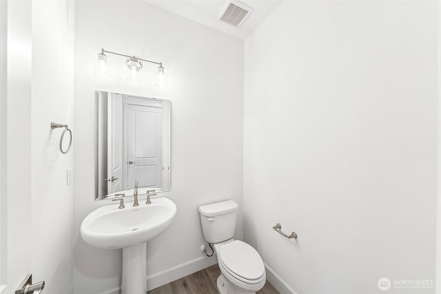 20304 150th St E, Bonney Lake, WA 98391 - half bathroom featuring wood finished floors, toilet, and baseboards