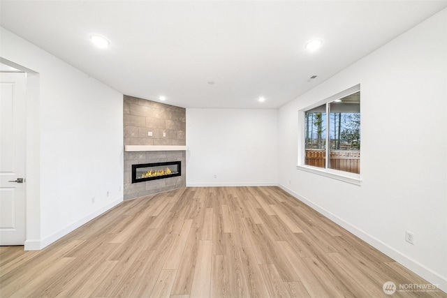 20304 150th St E, Bonney Lake, WA 98391 - unfurnished living room with light wood finished floors, a fireplace, baseboards, and recessed lighting