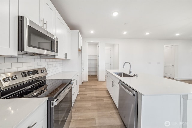 20304 150th St E, Bonney Lake, WA 98391 - kitchen featuring stainless steel appliances, a sink, recessed lighting, light wood-type flooring, and light countertops