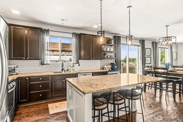912 77th Dr SE, Lake Stevens, WA 98258 - kitchen with a sink, dark brown cabinets, dark wood-type flooring, backsplash, and a center island
