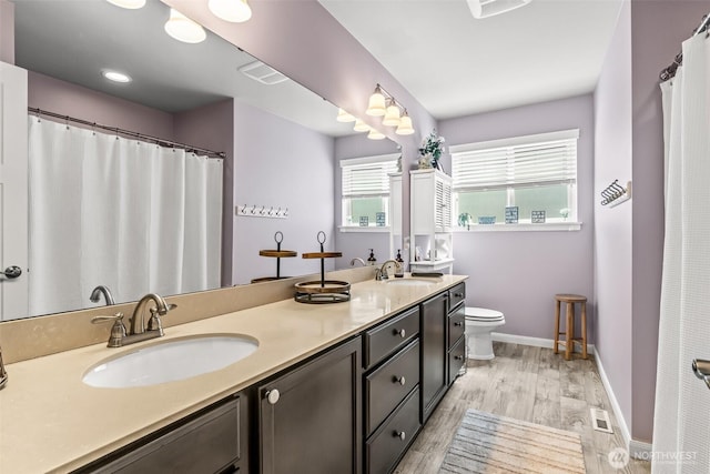 912 77th Dr SE, Lake Stevens, WA 98258 - bathroom featuring double vanity, wood finished floors, healthy amount of natural light, and toilet