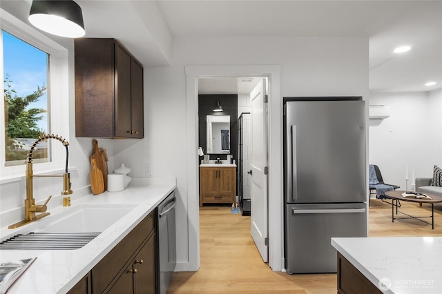 11550 22nd Ave NE, Seattle, WA 98125 - kitchen featuring appliances with stainless steel finishes, a sink, dark brown cabinetry, light wood-type flooring, and recessed lighting