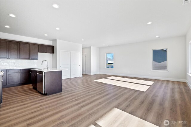 4247 W Sandy Ct, Moses Lake, WA 98837 - kitchen with a sink, dark brown cabinetry, open floor plan, light countertops, and stainless steel dishwasher