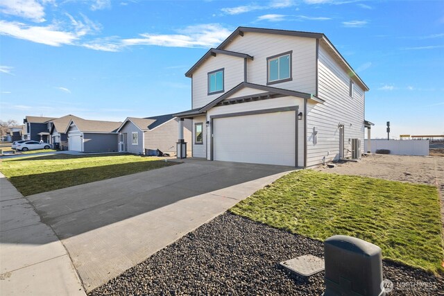 4247 W Sandy Ct, Moses Lake, WA 98837 - traditional home with driveway, a garage, and a front lawn