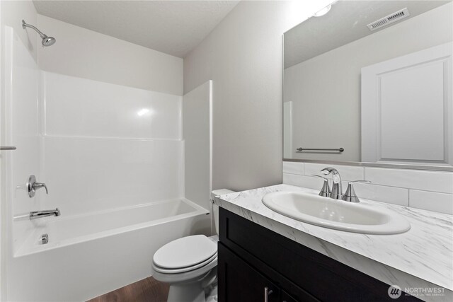 202 N Sandy Loop, Moses Lake, WA 98837 - full bathroom with toilet, vanity, bathing tub / shower combination, decorative backsplash, and wood finished floors