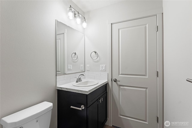 202 N Sandy Loop, Moses Lake, WA 98837 - bathroom featuring vanity, toilet, and tasteful backsplash