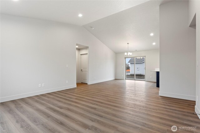202 N Sandy Loop, Moses Lake, WA 98837 - unfurnished living room with vaulted ceiling, a chandelier, recessed lighting, baseboards, and wood finished floors