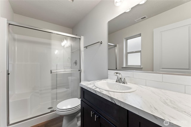 202 N Sandy Loop, Moses Lake, WA 98837 - full bathroom with toilet, vanity, a stall shower, and wood finished floors
