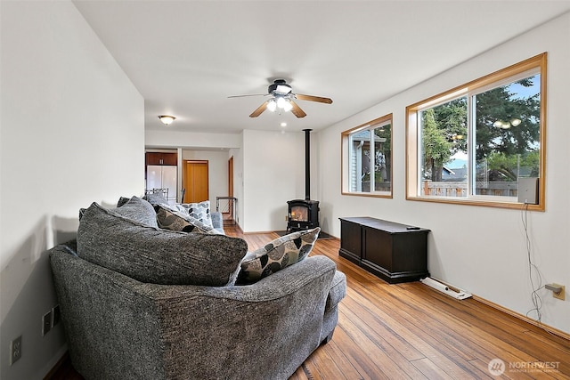 1165 Harding St, Enumclaw, WA 98022 - living area featuring a wood stove, a ceiling fan, and light wood finished floors