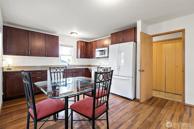 1165 Harding St, Enumclaw, WA 98022 - kitchen featuring white appliances, dark wood finished floors, dark brown cabinets, and a sink