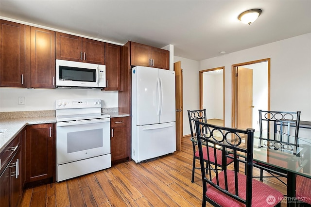 1165 Harding St, Enumclaw, WA 98022 - kitchen featuring white appliances, wood finished floors, and dark brown cabinets