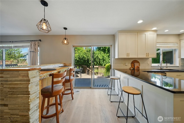 1210 Southview Dr, Walla Walla, WA 99362 - kitchen with plenty of natural light, a breakfast bar area, light wood-style floors, and recessed lighting