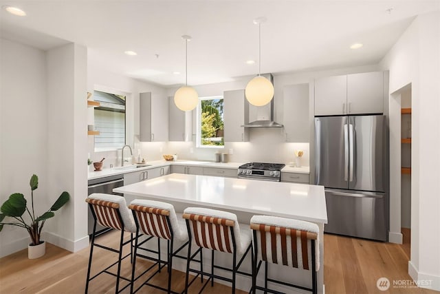 10304 NE 113th Pl Unit B, Kirkland, WA 98033 - kitchen featuring stainless steel appliances, a sink, a breakfast bar, light countertops, and light wood-type flooring