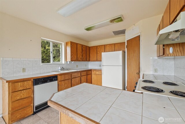 300 N St, Sequim, WA 98382 - kitchen featuring white appliances, under cabinet range hood, a peninsula, a sink, and decorative backsplash