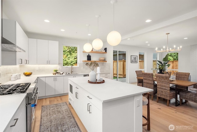 10304 NE 113th Pl, Kirkland, WA 98033 - kitchen featuring stainless steel stove, light wood finished floors, decorative backsplash, a kitchen island, and recessed lighting