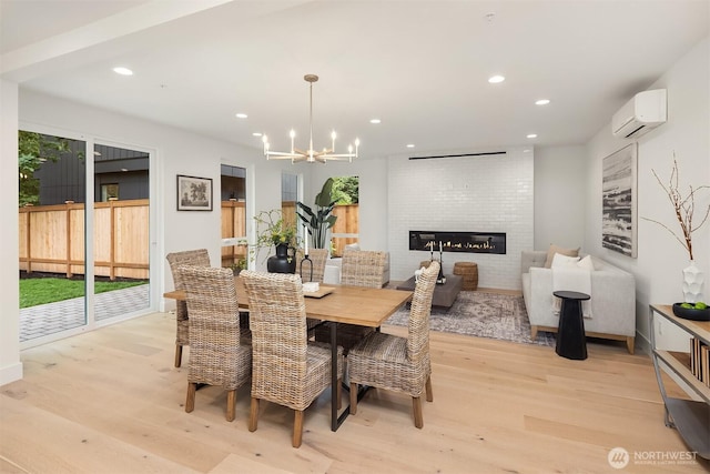 10304 NE 113th Pl, Kirkland, WA 98033 - dining space with a wall mounted AC, light wood finished floors, a chandelier, a large fireplace, and recessed lighting