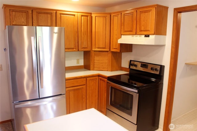 19494 N N Pl, Long Beach, WA 98631 - kitchen featuring appliances with stainless steel finishes, under cabinet range hood, light countertops, and brown cabinetry