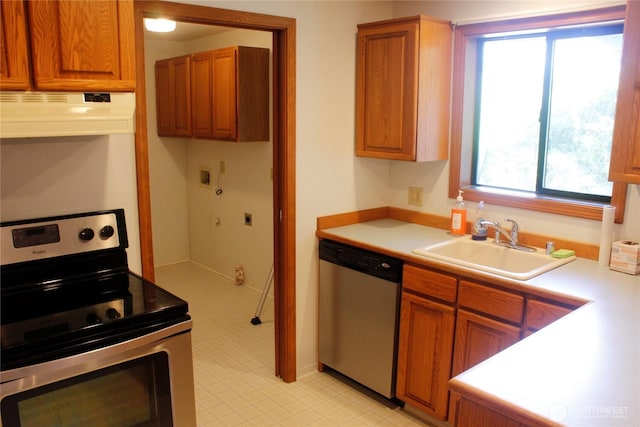 19494 N N Pl, Long Beach, WA 98631 - kitchen with stainless steel appliances, under cabinet range hood, a sink, light countertops, and brown cabinets