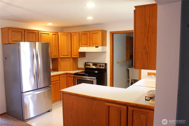 19494 N N Pl, Long Beach, WA 98631 - kitchen with stainless steel appliances, under cabinet range hood, a sink, a peninsula, and light countertops