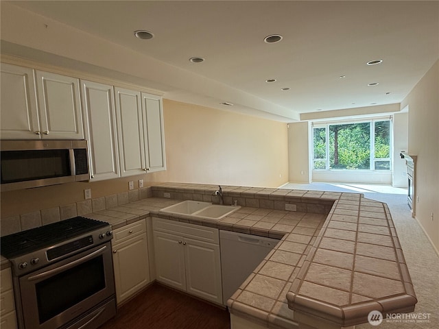 1805 134th Ave NE Unit 8, Bellevue, WA 98005 - kitchen featuring appliances with stainless steel finishes, a sink, a peninsula, tile counters, and white cabinets