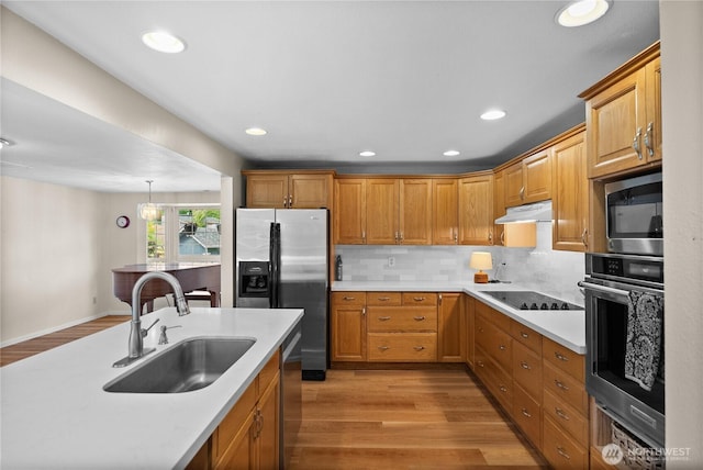 12012 County Line Rd E, Edgewood, WA 98372 - kitchen featuring appliances with stainless steel finishes, light wood-style flooring, light countertops, under cabinet range hood, and recessed lighting