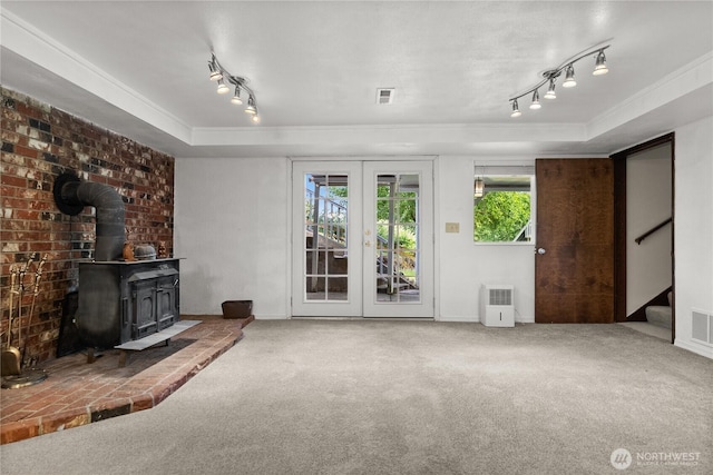12012 County Line Rd E, Edgewood, WA 98372 - unfurnished living room with crown molding, track lighting, carpet floors, french doors, and a wood stove