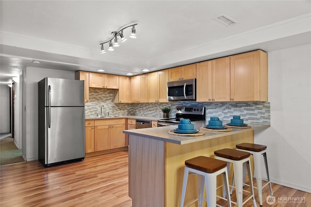 12012 County Line Rd E, Edgewood, WA 98372 - kitchen featuring stainless steel appliances, light brown cabinetry, a peninsula, and tasteful backsplash