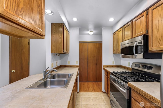 873 Fern Dr, Lynden, WA 98264 - kitchen featuring stainless steel appliances, a sink, brown cabinets, recessed lighting, and tile counters