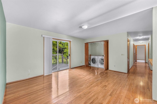 873 Fern Dr, Lynden, WA 98264 - unfurnished living room with washing machine and dryer, light wood-style flooring, and baseboards