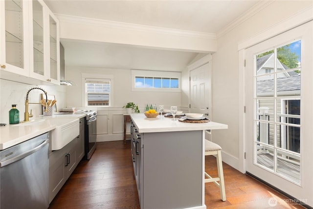 707 N Adams St, Tacoma, WA 98406 - kitchen featuring appliances with stainless steel finishes, a kitchen breakfast bar, a sink, dark wood-style flooring, and gray cabinetry