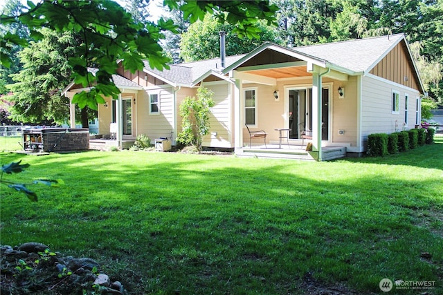 17247 154th Ave SE, Yelm, WA 98597 - back of house featuring board and batten siding, a yard, and a hot tub