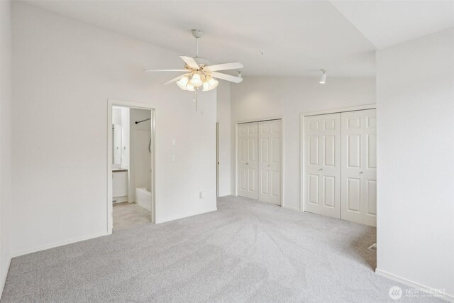 21616 9th Ave SE Unit C-105, Bothell, WA 98021 - unfurnished bedroom featuring vaulted ceiling, two closets, carpet flooring, ensuite bathroom, and a ceiling fan