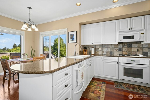 12232 SE 80th Way, Newcastle, WA 98056 - kitchen featuring white appliances, a sink, a peninsula, dark wood-type flooring, and tasteful backsplash
