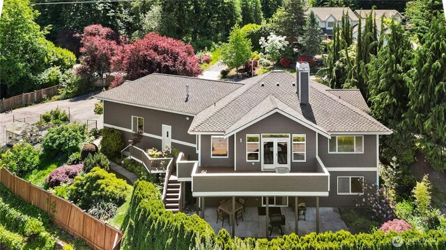 12232 SE 80th Way, Newcastle, WA 98056 - back of house with stairway, a patio area, a chimney, a shingled roof, and view of scattered trees