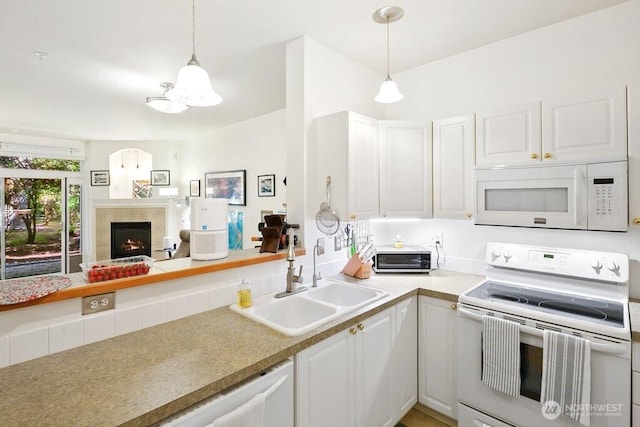12712 Admiralty Way Unit G102, Everett, WA 98204 - kitchen featuring white appliances, a sink, white cabinets, and a premium fireplace