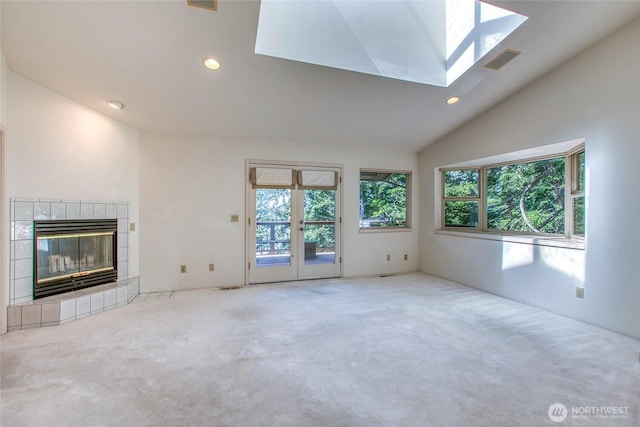 121 Switchback Rd, Orcas Island, WA 98245 - unfurnished living room with carpet, vaulted ceiling, a tile fireplace, french doors, and recessed lighting