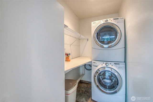 121 Switchback Rd, Orcas Island, WA 98245 - laundry room featuring stacked washer / dryer and stone finish flooring
