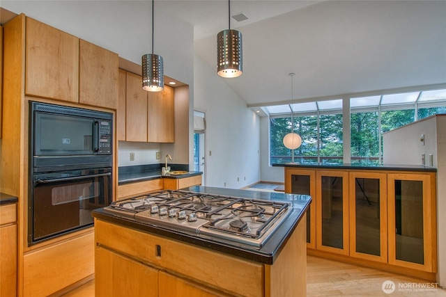 121 Switchback Rd, Orcas Island, WA 98245 - kitchen featuring black appliances, dark countertops, a center island, glass insert cabinets, and hanging light fixtures