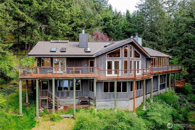 121 Switchback Rd, Orcas Island, WA 98245 - rear view of house featuring a chimney, a deck, and a forest view