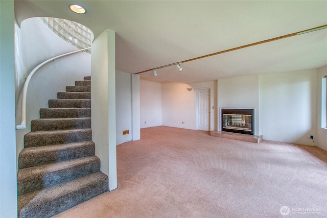 121 Switchback Rd, Orcas Island, WA 98245 - unfurnished living room with carpet floors, stairs, a glass covered fireplace, and rail lighting