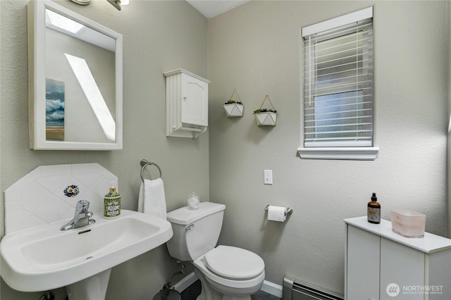 6610 6th Ave SE, Lacey, WA 98503 - half bathroom with a baseboard radiator, a sink, toilet, and decorative backsplash