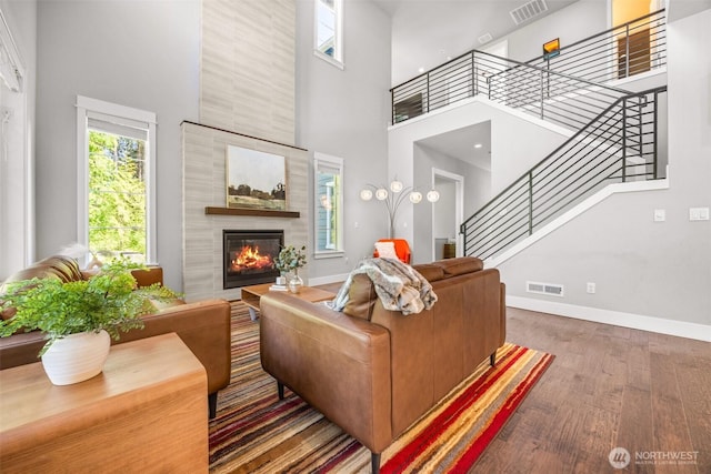 21888 SE 5th Pl, Sammamish, WA 98074 - living area featuring a high ceiling, wood finished floors, stairway, baseboards, and a tiled fireplace